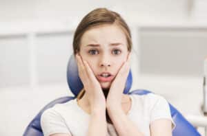 A teen with TMJ sitting in an orthodontist's chair