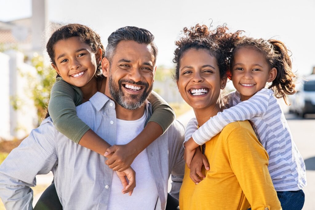 Multiethnic parents giving children piggyback ride 1766076353 iStock 1270066890 1 Orthodontics in Denver CO