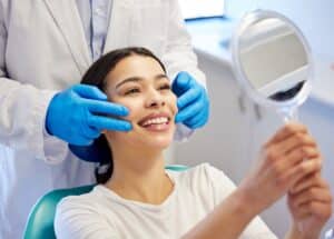 A woman looking in the mirror at aesthetic changes after jaw surgery