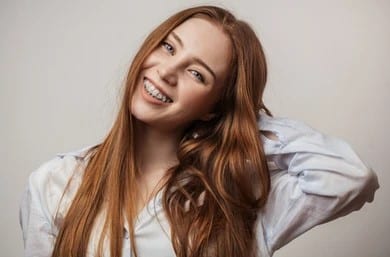 happy young redhaired woman braces 260nw 1089826847 Ceramic Braces in Denver, CO
